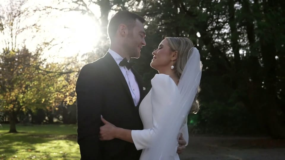 A bride and groom embrace in golden autumn light at Luttrellstown Castle